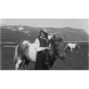 Kona heldur i hest i furufirdi
